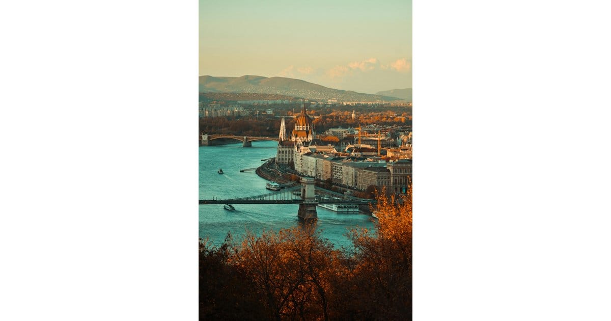 Mit HUNCONSULT nach Ungarn expandieren Expansion nach Ungarn: Geschäftsmann vor Budapester Skyline mit ungarischer Flagge und Eurozeichen